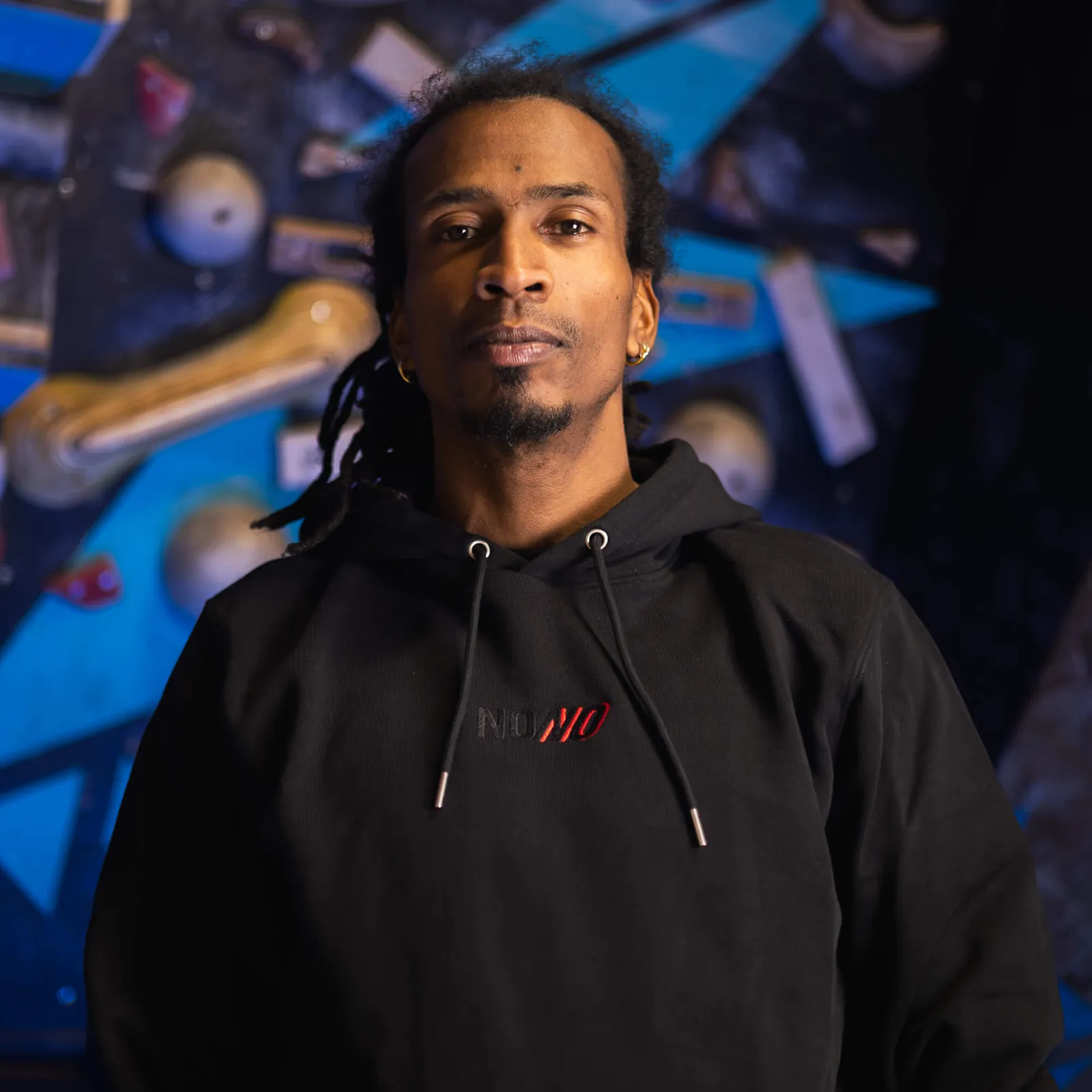 Man wearing the black NONO Signature Hoodie in a climbing gym